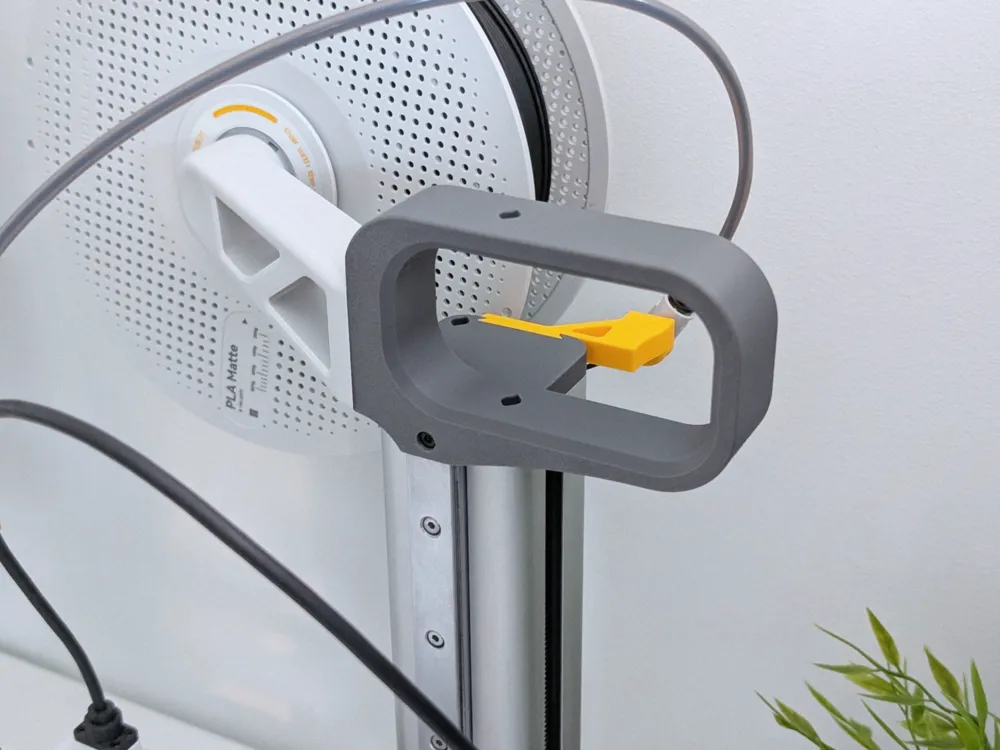 Grey 3D-printed carry handle mounted on the mast of a Bambu Lab A1 mini, with the original white spool holder still fitted behind it