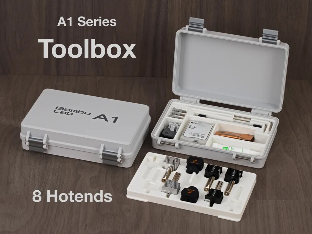 Two 3D-printed A1 toolboxes on a wooden desk, one closed with a Bambu Lab A1 logo and one open showing tools and a tray of eight hotends