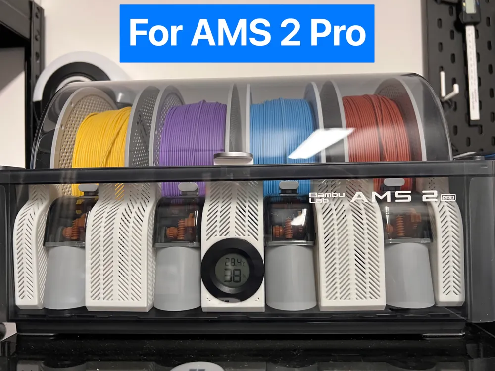 3D-printed desiccant boxes slotted between filament spools in the AMS 2 Pro