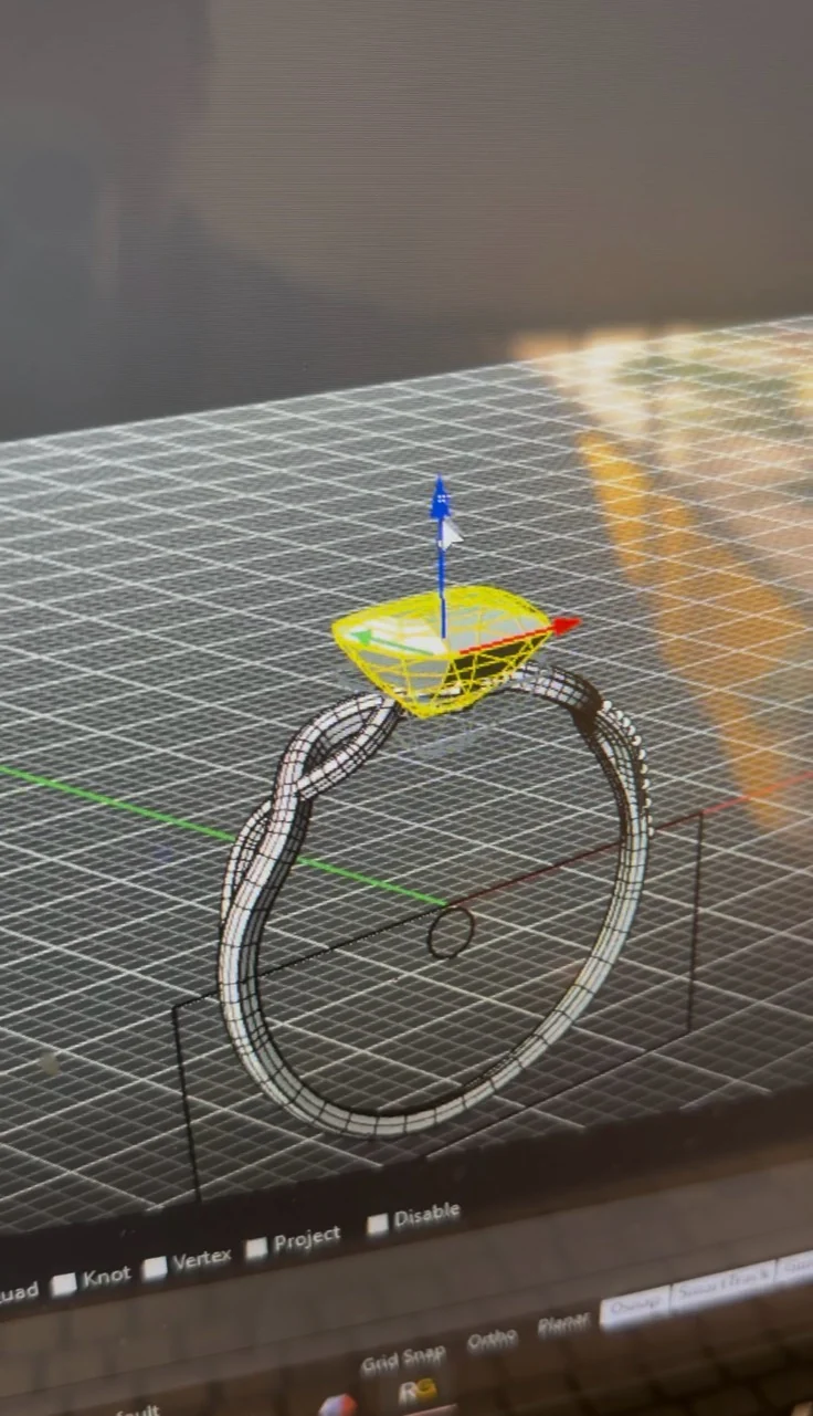 A ring design on a computer screen, with its shape and stone setting visible