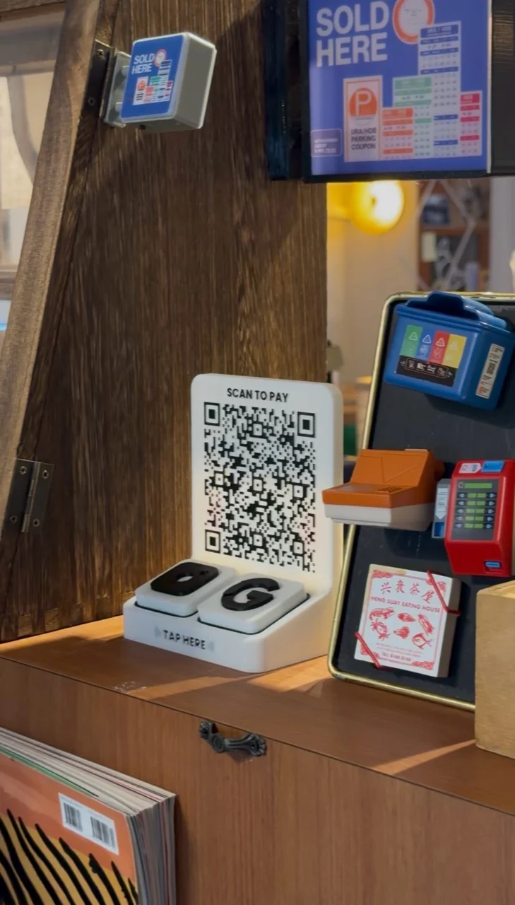 An NFC stand in use on a wooden shop counter