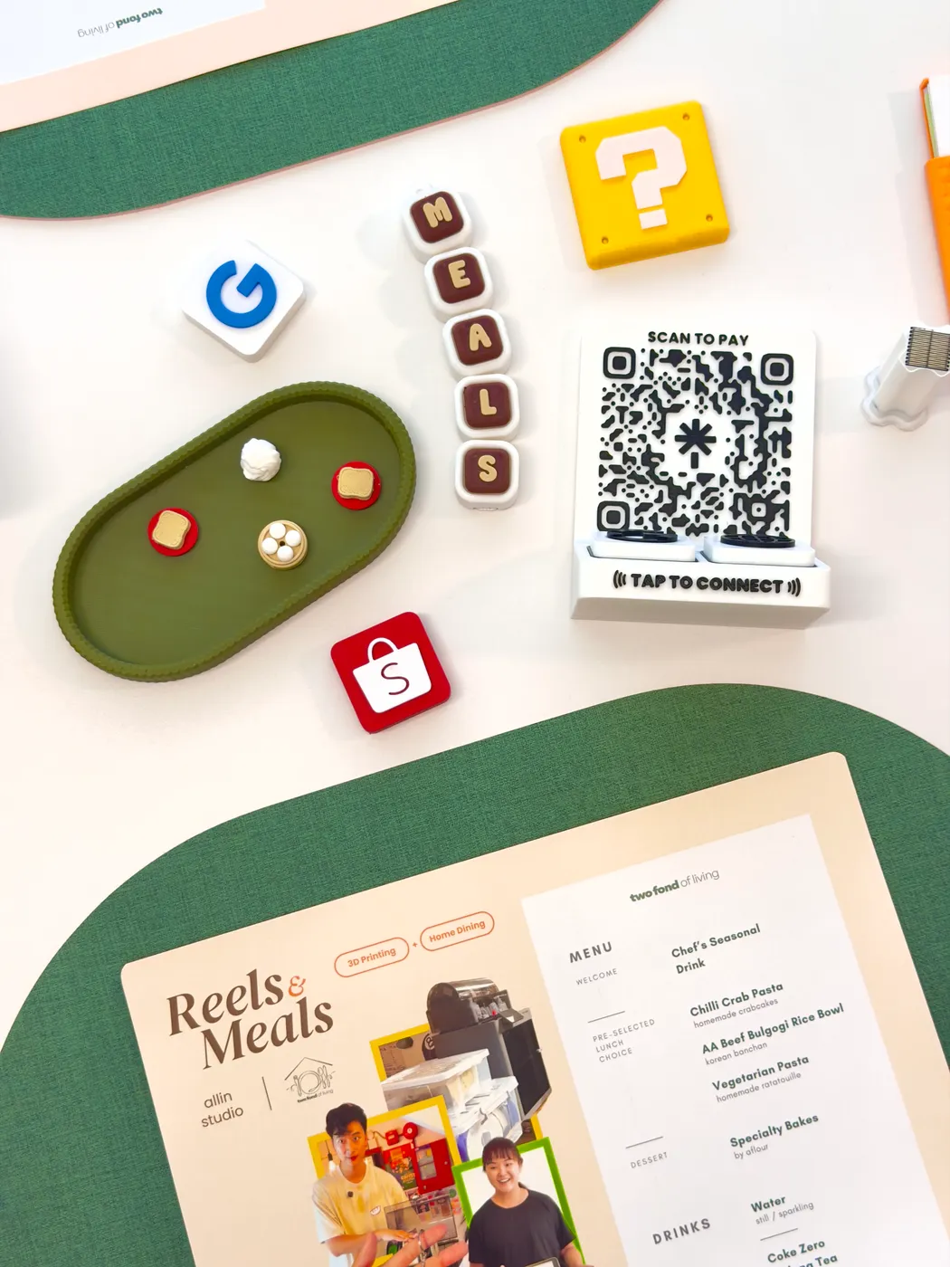 A Reels & Meals table set with the menu, printed tiles and a tap-to-pay stand