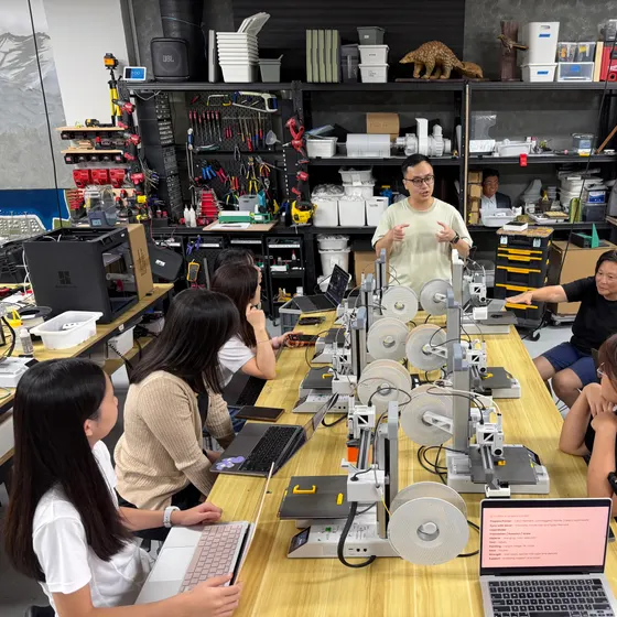 学员围在工作室的打印机工作台旁